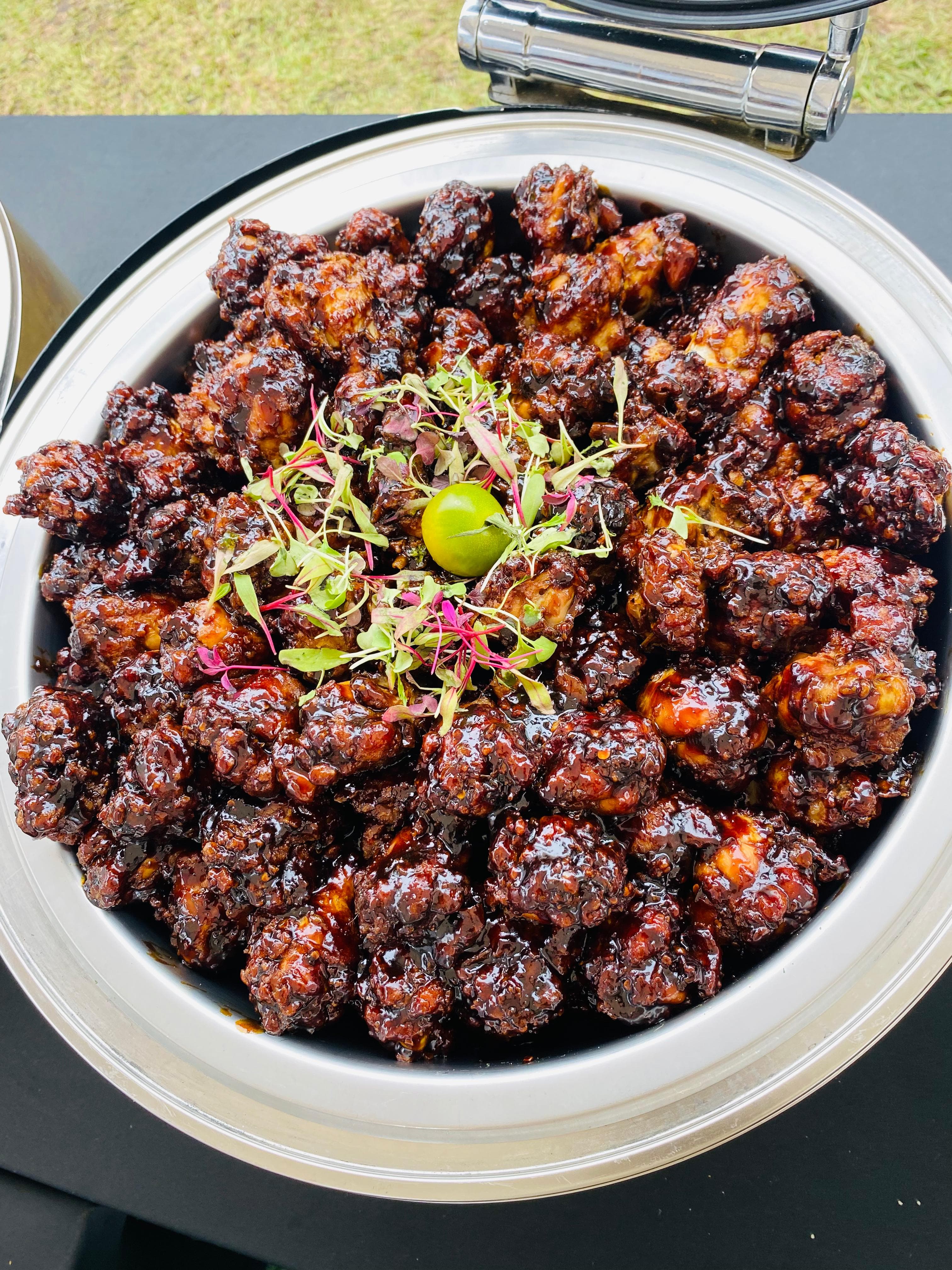 Glazed chicken pieces garnished with lime and microgreens