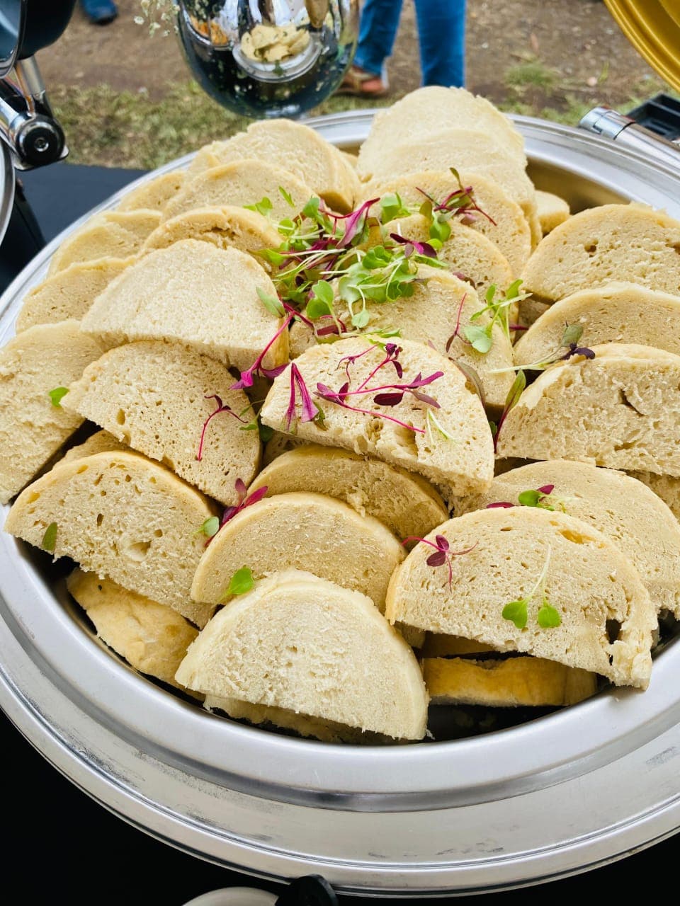 Sliced steamed bread (ujeqe) garnished with microgreens